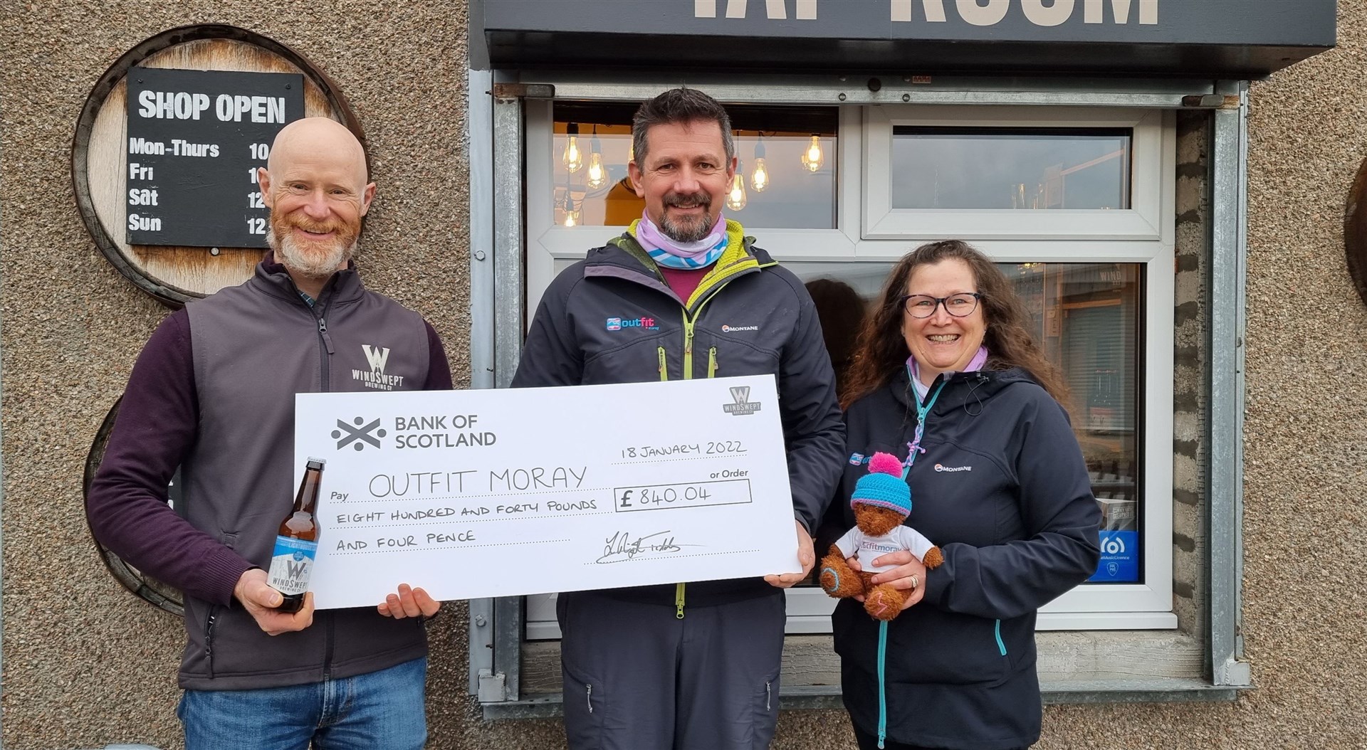 Nigel Tiddy, left, hands over a cheque for £840 to Outfit Moray.
